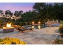 A luxury backyard features an in-ground pool, jacuzzi, sun loungers, and a fire pit, perfect for relaxing at night at 3829 Westbury Lake Dr, Raleigh, NC 27603