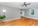 Bright living room with hardwood floors, gray walls, white trim and a modern ceiling fan at 4420 W River Rd, Franklinton, NC 27525