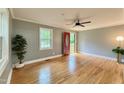 Bright living room features hardwood floors, large windows, and a modern ceiling fan at 4420 W River Rd, Franklinton, NC 27525
