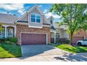 Beautiful townhome with a two-car garage, stone accents, and professionally landscaped front yard at 5045 Homeplace Dr, Apex, NC 27539