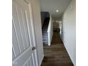 Inviting hallway with durable wood floors, stairs, and neutral paint leads to the home's main living area at 51 Commons Cir, Clayton, NC 27520