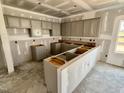Unfinished kitchen with gray cabinets, an island, and ample space for customization at 51 Commons Cir, Clayton, NC 27520