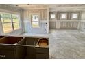 Spacious living room featuring multiple windows for ample natural light and bare drywall with cabinet details at 51 Commons Cir, Clayton, NC 27520