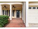Inviting front porch with a brick walkway, elegant columns, and a black front door at 5102 Highcroft Dr, Cary, NC 27519