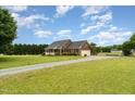 Expansive home with a long driveway, three-car garage and pool, surrounded by lush greenery at 5136 Liberty Grove Rd, Liberty, NC 27298