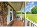 Inviting front porch with brick flooring, rocking chairs and a view of the front yard at 5136 Liberty Grove Rd, Liberty, NC 27298
