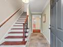 Bright foyer features tile floors, staircase with wood treads, and view to the living areas at 5409 Knollwood Rd Rd, Raleigh, NC 27609