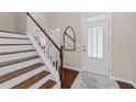 Elegant foyer showcasing hardwood floors, staircase with white railing, and a stylish front door at 5644 Wade Park Blvd, Raleigh, NC 27607