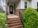 Inviting front porch with brick steps, black railings, and views of the lovely landscaping at 5644 Wade Park Blvd, Raleigh, NC 27607