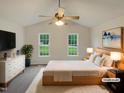 Bright bedroom featuring a ceiling fan, two windows, neutral walls, and a plush rug at 5749 Stone Crystal Dr, Fuquay Varina, NC 27526