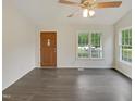 Well-lit living room featuring sleek hard wood floors and a contemporary ceiling fan at 5749 Stone Crystal Dr, Fuquay Varina, NC 27526