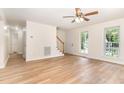 Bright and open living room with hardwood floors, ceiling fan, and staircase at 6321 Lymington Dr, Raleigh, NC 27616