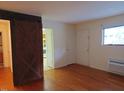 Open-concept room with hardwood floors and rustic barn door, offering ample space at 7 Shepherd Ln # Bldg D, Chapel Hill, NC 27514
