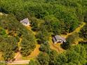A rural estate featuring a home and barn enveloped by lush trees, providing privacy and a natural setting at 815 Solitude Pt, Chapel Hill, NC 27516