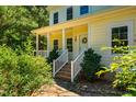 Inviting home entrance with a charming porch, brick steps, classic white railings and attractive landscaping at 815 Solitude Pt, Chapel Hill, NC 27516