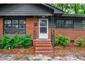 A close-up of the front entrance with brick stairs and black iron railings at 829 Burton St, Rocky Mount, NC 27803