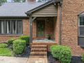 Close-up of the brick home's entrance, showcasing well-maintained landscaping and a welcoming doorway at 8509 Oneal Rd, Raleigh, NC 27613