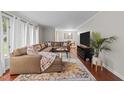 Inviting living room with a large sectional sofa, hardwood floors, and bright natural light at 8509 Oneal Rd, Raleigh, NC 27613