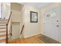 Welcoming entryway with hardwood floors, a stylish mirror, and a staircase leading to the upper level at 1000 Winona Rd, Raleigh, NC 27609