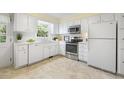 Bright kitchen with white cabinets, stainless steel appliances, and a window overlooking the backyard at 1000 Winona Rd, Raleigh, NC 27609