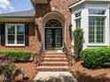 Inviting brick home featuring a double door entrance, complemented by lush landscaping at 101 Temple Gate Dr, Cary, NC 27518