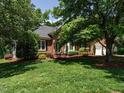 Beautiful brick home surrounded by lush greenery and mature trees, offering a serene and private setting at 101 Temple Gate Dr, Cary, NC 27518