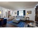 Relaxing living room with hardwood floors, neutral walls, blue accents, and views of the staircase and front door at 103 Uxbridge Ct, Cary, NC 27513