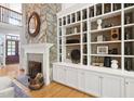 Close up of fireplace with stone accent and built-in shelving with decor at 10405 Veasey Mill Rd, Raleigh, NC 27615