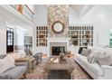 Bright living room features stone fireplace, built-in shelves, and soaring ceilings at 10405 Veasey Mill Rd, Raleigh, NC 27615