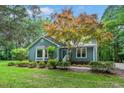 Inviting blue home with landscaped yard and a beautiful tree accentuating the entrance at 10816 Bent Branch Dr, Raleigh, NC 27603