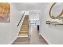 Inviting foyer featuring pristine hardwood floors, a staircase, and decorative wall accents at 1156 Craigmeade Dr, Morrisville, NC 27560