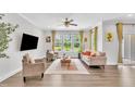 Bright living room with large windows, hardwood floors, contemporary furnishings, and a ceiling fan at 1156 Craigmeade Dr, Morrisville, NC 27560