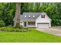 Charming white house featuring a well-maintained lawn, a two-car garage, and a cozy front porch at 119 Valleycastle Ct, Clayton, NC 27520
