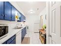 Well-lit kitchen features matching appliances, ample counter space, and blue painted cabinets at 1200 Schaub Dr # G, Raleigh, NC 27606