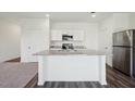 Open concept kitchen features white cabinets, stainless appliances, and a granite-topped island at 1205 Solace Way, Rolesville, NC 27571