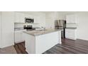 Bright kitchen with white cabinets, stainless steel appliances, and a granite-topped island at 1205 Solace Way, Rolesville, NC 27571