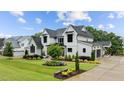 Landscaped front yard, dark trim, white painted brick on a traditional two story home at 1229 Perry Bluff Dr, Wake Forest, NC 27587