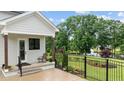 Covered patio with fence overlooking the landscaped backyard and pond at 1229 Perry Bluff Dr, Wake Forest, NC 27587