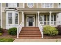 Inviting front porch with brick steps, white railings, and decorative columns at front door at 128 Low Country Ct, Morrisville, NC 27560