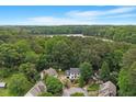 Breathtaking aerial view of the property nestled among lush trees and overlooking a scenic lake at 1312 Stonemoor Ct, Raleigh, NC 27606