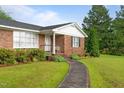 Brick home exterior, featuring a curved walkway leading to a charming covered front porch at 1517 Hodges Chapel Rd, Benson, NC 27504