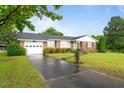 Beautiful single story brick house with lush green lawn, long driveway, and attached garage at 1517 Hodges Chapel Rd, Benson, NC 27504