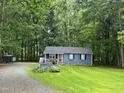 Charming single-story home with blue siding, flower boxes and lush green lawn surrounded by mature trees at 1634 Hurdle Mills Rd, Roxboro, NC 27574
