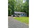 Charming home features a cozy front porch, blue siding and well-manicured landscaping at 1634 Hurdle Mills Rd, Roxboro, NC 27574