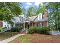 Charming brick home featuring dormer windows, black shutters, and a neatly landscaped front yard at 1703 Berwickshire Cir, Raleigh, NC 27615