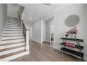 Bright foyer with hardwood floors, staircase with iron spindles, and elegant decor, creating a welcoming entry at 192 Logbridge Rd, Chapel Hill, NC 27516