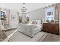 Inviting bedroom with a tufted headboard bed, neutral color scheme, ample natural light, and a decorative chandelier at 200 Sugar Pine Drive, Franklinton, NC 27525
