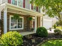 Charming covered front porch with stone and manicured greenery at 2012 Sterling Hill Dr, Fuquay Varina, NC 27526