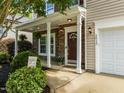 Inviting front porch with stone accents, a welcome sign, and lush landscaping at 2012 Sterling Hill Dr, Fuquay Varina, NC 27526