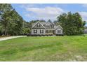 Beautiful gray home with black shutters and lush green lawn and tree line at 205 Sherman Pines Dr, Fuquay Varina, NC 27526